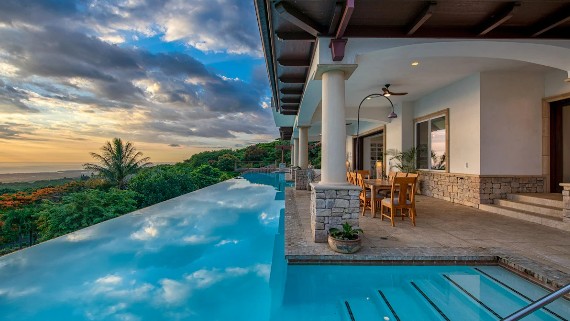 Infinity pool at sunset overlooking the ocean from a private Hawaiian estate